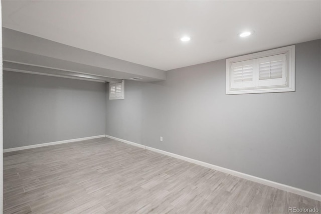 finished below grade area featuring light wood-type flooring, baseboards, and recessed lighting