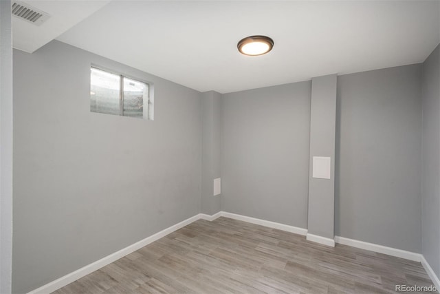 basement featuring light wood finished floors, baseboards, and visible vents