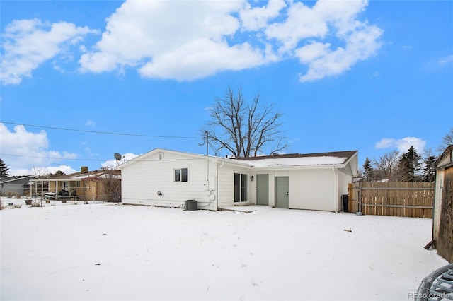 snow covered property with central air condition unit