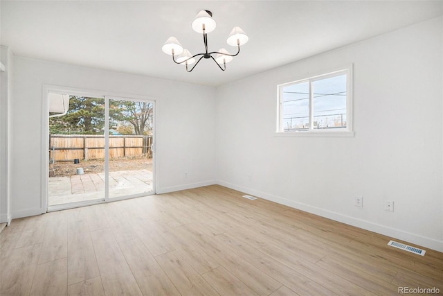 unfurnished room with light hardwood / wood-style floors and a chandelier