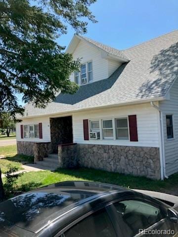 440 Colorado Ave, Stratton, CO 80836 - view of front of house with stone siding, roof with shingles, uncovered parking, and an outdoor hot tub
