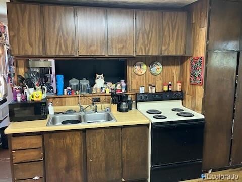 440 Colorado Ave, Stratton, CO 80836 - kitchen featuring white electric range, black microwave, and light countertops