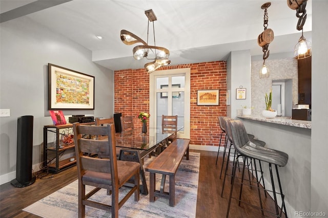 3410 Pecos St, Denver, CO 80211 - dining room with dark wood-type flooring, a chandelier, and brick wall