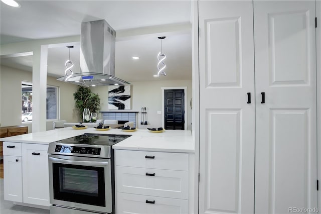 kitchen with stainless steel range with electric stovetop, light stone counters, decorative light fixtures, white cabinets, and island range hood