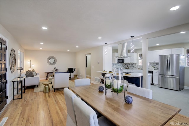 dining space featuring recessed lighting, baseboards, and light wood-style floors