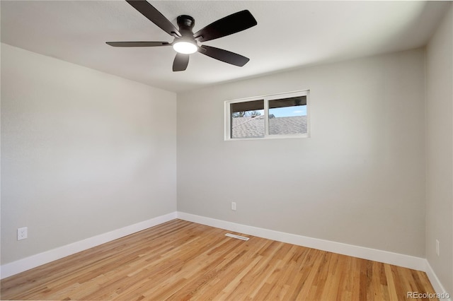 spare room featuring light wood-style flooring, a ceiling fan, and baseboards