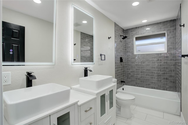 bathroom with double vanity, shower / bath combination, toilet, and a sink