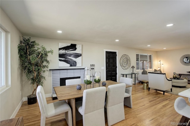 dining space featuring recessed lighting, light wood-style floors, and a fireplace