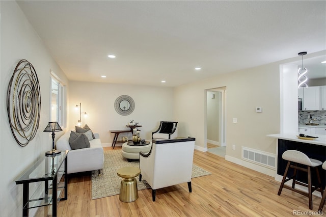 living room featuring recessed lighting, visible vents, baseboards, and light wood-style floors