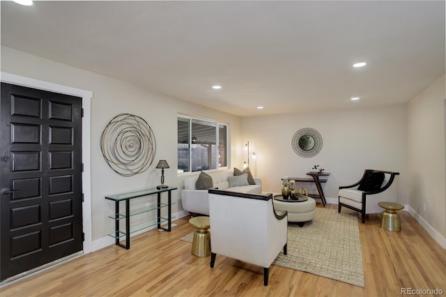 living room with recessed lighting, light wood-style floors, and baseboards