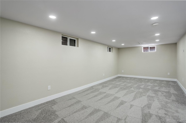 basement with recessed lighting, light colored carpet, and baseboards