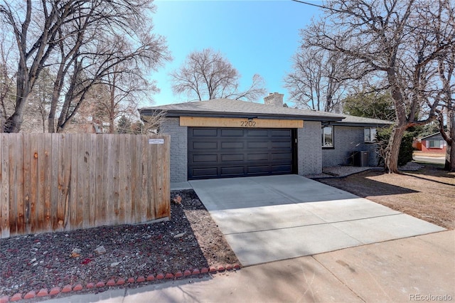 exterior space featuring concrete driveway, fence, and central AC