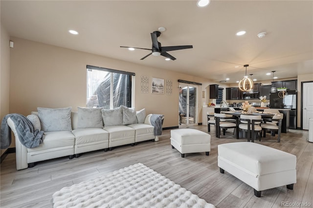 living room with ceiling fan and light hardwood / wood-style flooring