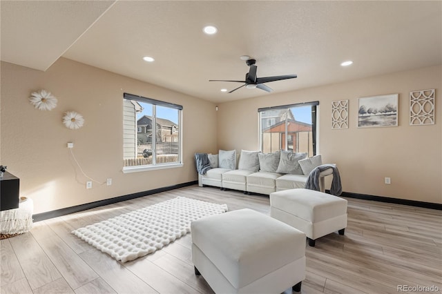 living room featuring ceiling fan, a wealth of natural light, and light hardwood / wood-style floors