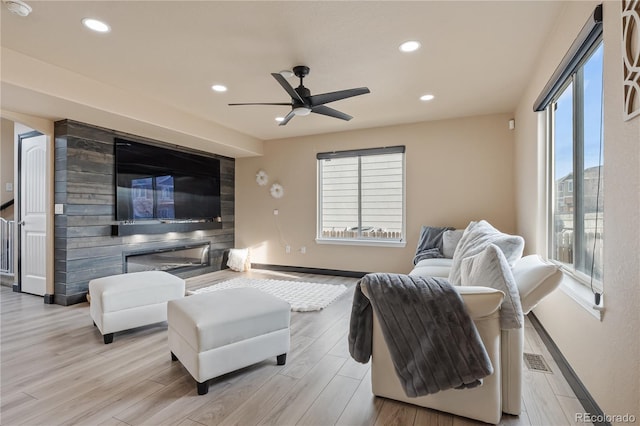 living room with light hardwood / wood-style flooring and ceiling fan