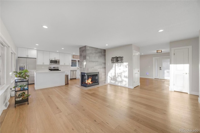 unfurnished living room with light hardwood / wood-style floors and a tile fireplace