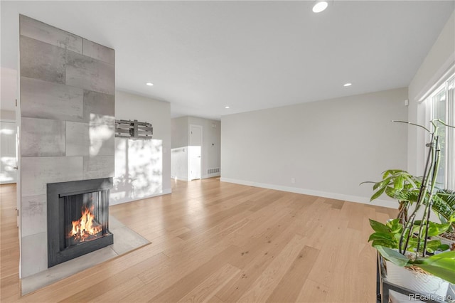 unfurnished living room with light hardwood / wood-style flooring and a fireplace