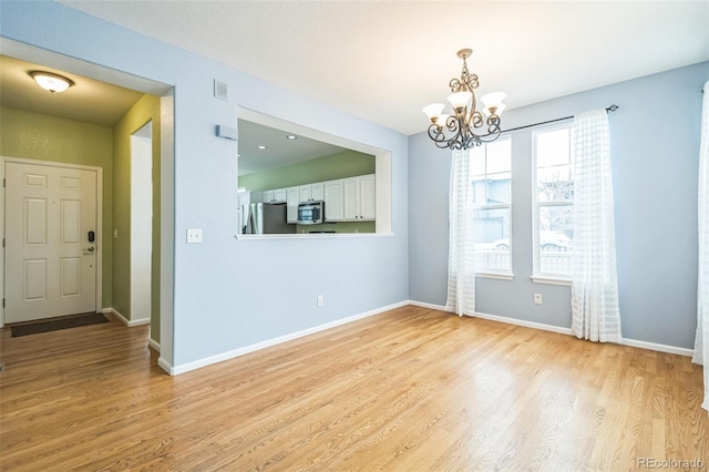 interior space with light wood-type flooring and a chandelier