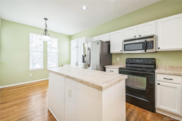 kitchen featuring a center island, hanging light fixtures, white cabinetry, wood-type flooring, and stainless steel appliances