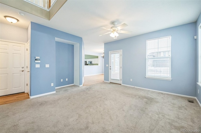 empty room featuring ceiling fan and light carpet