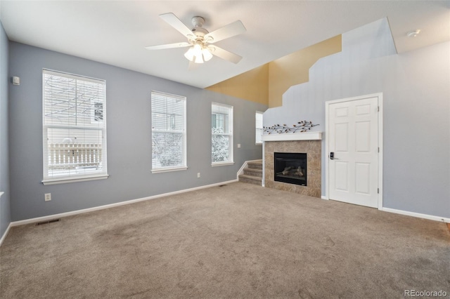 unfurnished living room featuring a fireplace, carpet floors, and ceiling fan