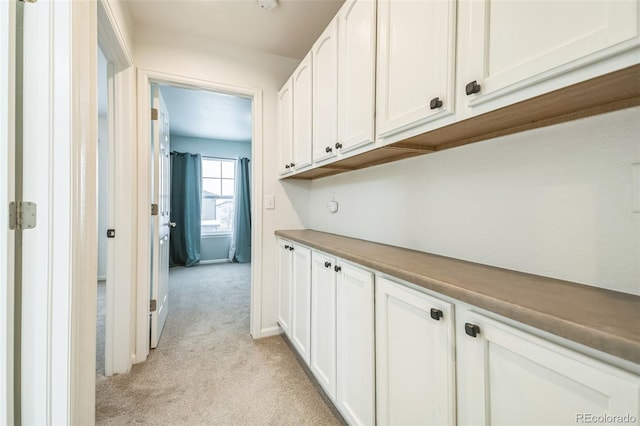 hallway featuring light colored carpet