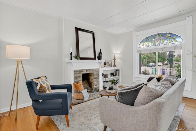 274 S Lincoln St, Denver, CO 80209 - living room with ornamental molding, a stone fireplace, and wood finished floors