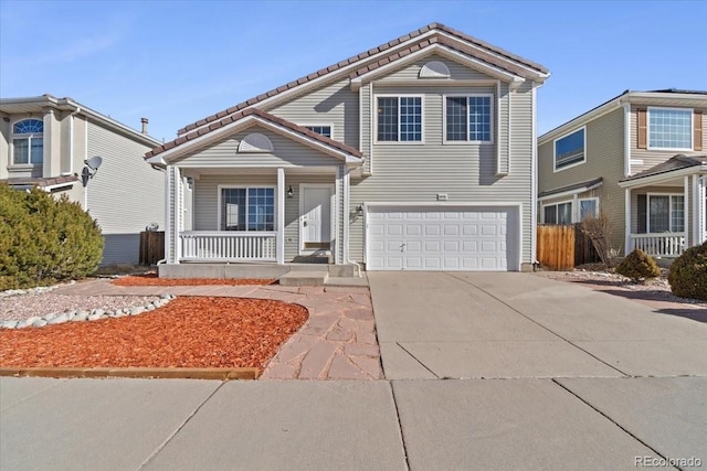 traditional-style house featuring a porch, concrete driveway, an attached garage, and fence