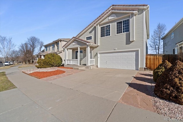 view of front of house featuring a garage, concrete driveway, and fence