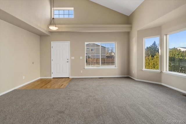 interior space with baseboards, high vaulted ceiling, and carpet