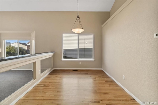 unfurnished dining area featuring light wood-style floors and baseboards