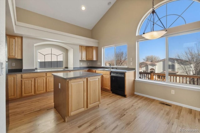 kitchen with visible vents, dishwasher, a kitchen island, and light wood-style floors