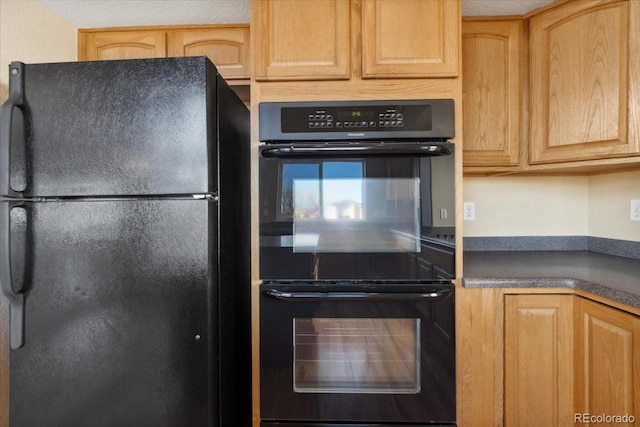 kitchen featuring dark countertops, black appliances, and light brown cabinetry