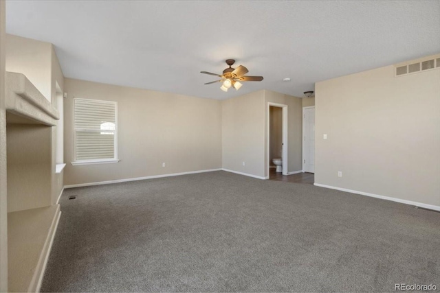 unfurnished room with visible vents, baseboards, ceiling fan, and dark colored carpet