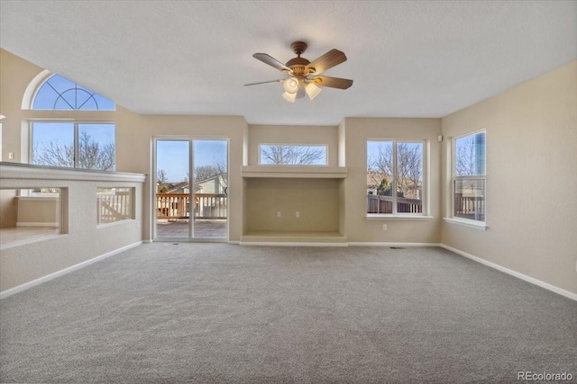 unfurnished living room featuring a textured ceiling, baseboards, carpet, and a ceiling fan