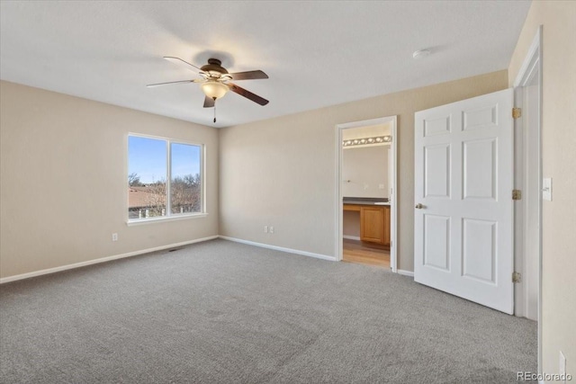 unfurnished bedroom with connected bathroom, baseboards, carpet, and ceiling fan