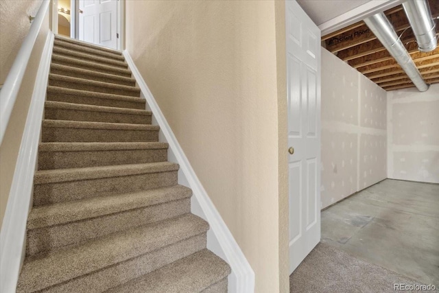 stairway with concrete floors and a textured wall