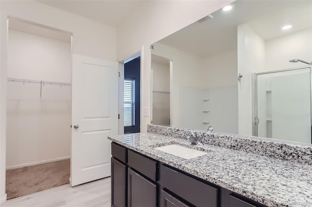 bathroom featuring vanity, wood-type flooring, and a shower