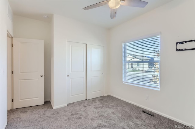 unfurnished bedroom with light carpet, a closet, and ceiling fan