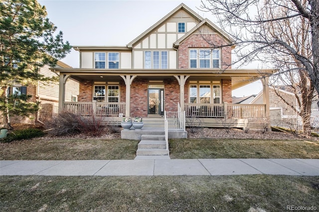 tudor-style house with covered porch and brick siding