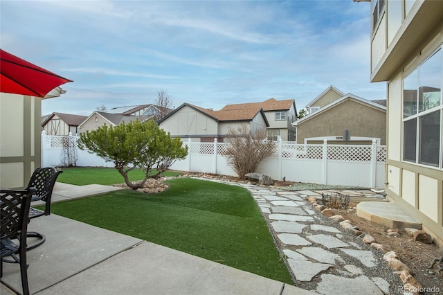 view of yard with a fenced backyard, a patio area, and a residential view