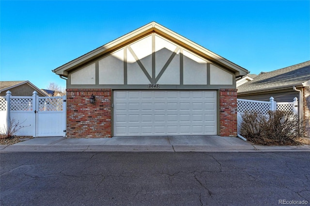 garage featuring fence and a gate