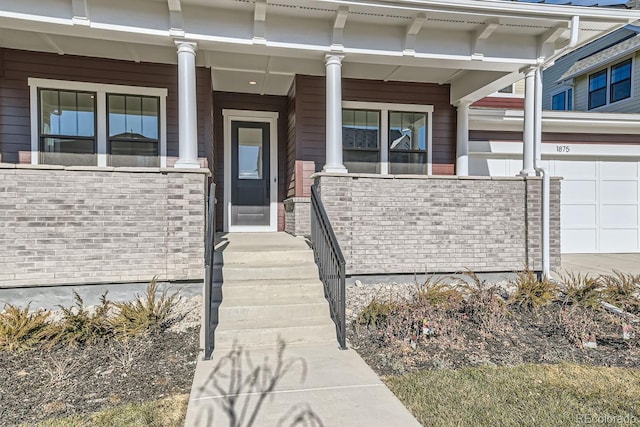 doorway to property featuring a garage and brick siding