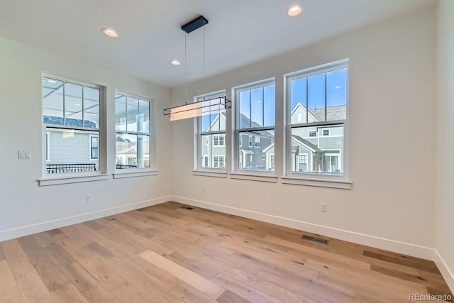 unfurnished dining area featuring a wealth of natural light, recessed lighting, light wood-type flooring, and baseboards