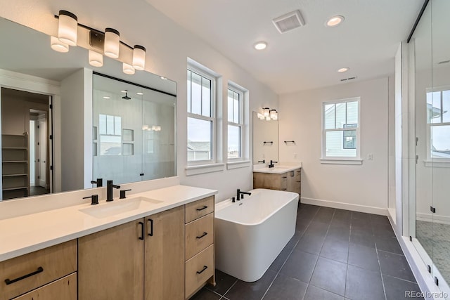 bathroom with a shower stall, recessed lighting, visible vents, and a sink