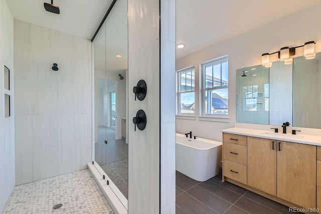 full bathroom with tiled shower, a freestanding bath, vanity, and tile patterned flooring