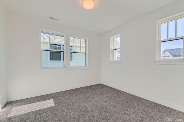 carpeted empty room with visible vents and baseboards