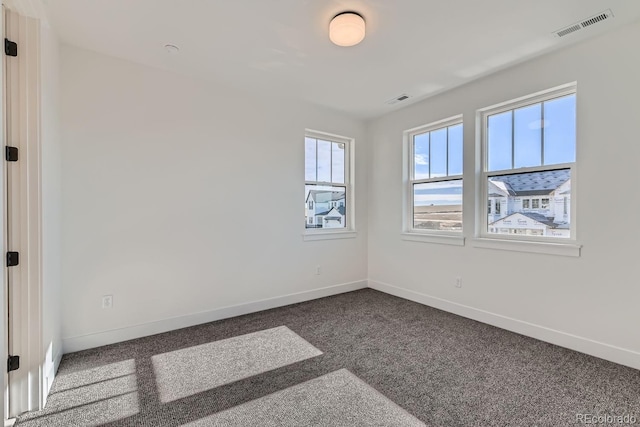 carpeted empty room with visible vents and baseboards