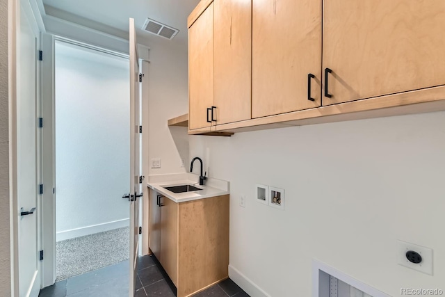 clothes washing area featuring visible vents, hookup for an electric dryer, cabinet space, a sink, and washer hookup