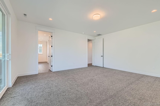 carpeted spare room featuring visible vents, recessed lighting, and baseboards